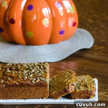 Pumpkin bread in front of a ceramic pumpkin.