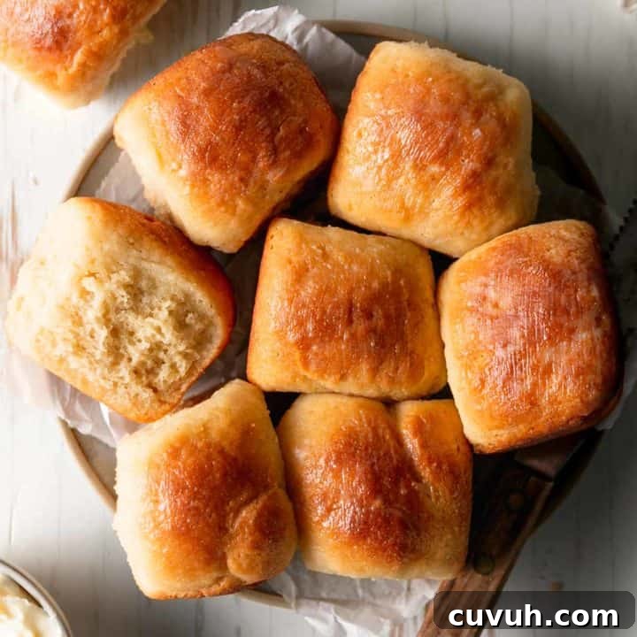 A plate of gluten free Hawaiian rolls, one on it's side to show texture.