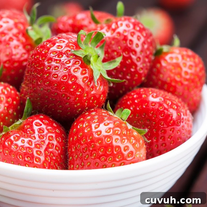 A bowl of fresh strawberries on wooden background