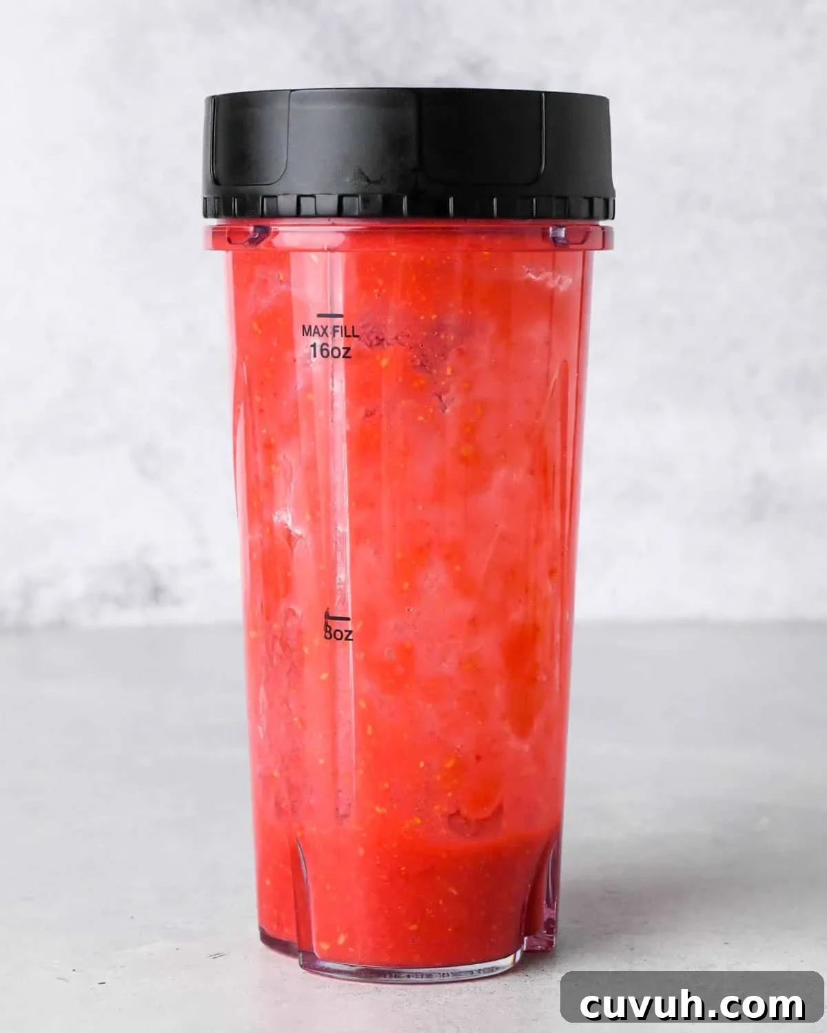 how to make raspberry frosting - raspberries and sugar in a small blending container after blending overhead view front view