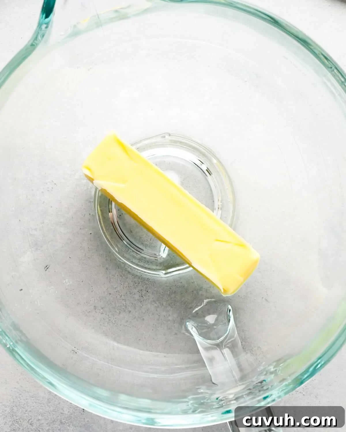 how to make raspberry frosting - a stick of butter in a glass mixing bowl
