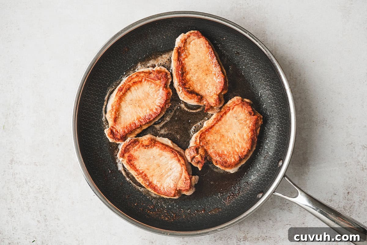 Boneless pork loin chops in a skillet.