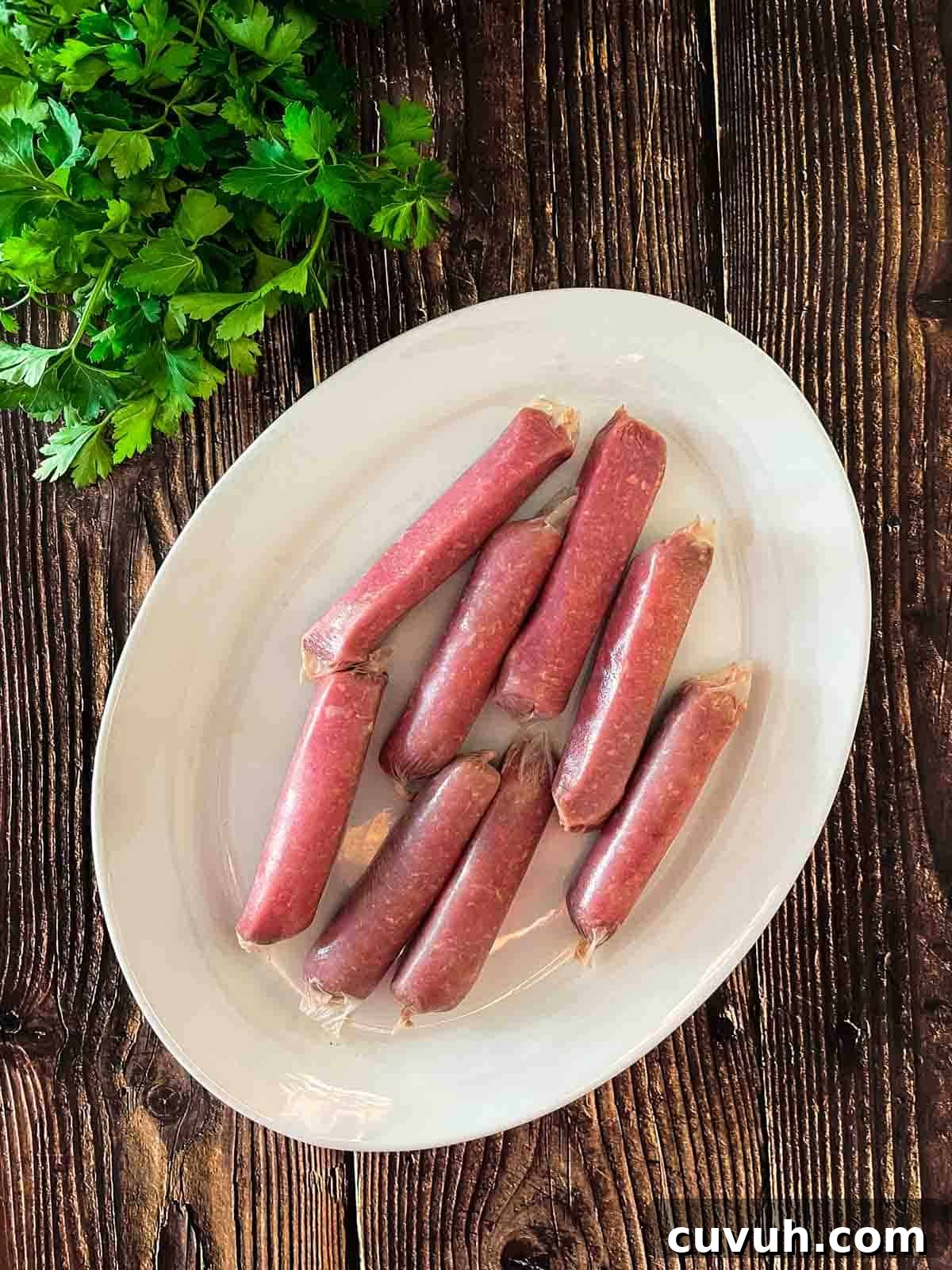 Crispy Juicy Air Fryer Breakfast Sausages in 15 Minutes 3 Breakfast sausages are the only ingredients for this recipe, placed on a white plate.
