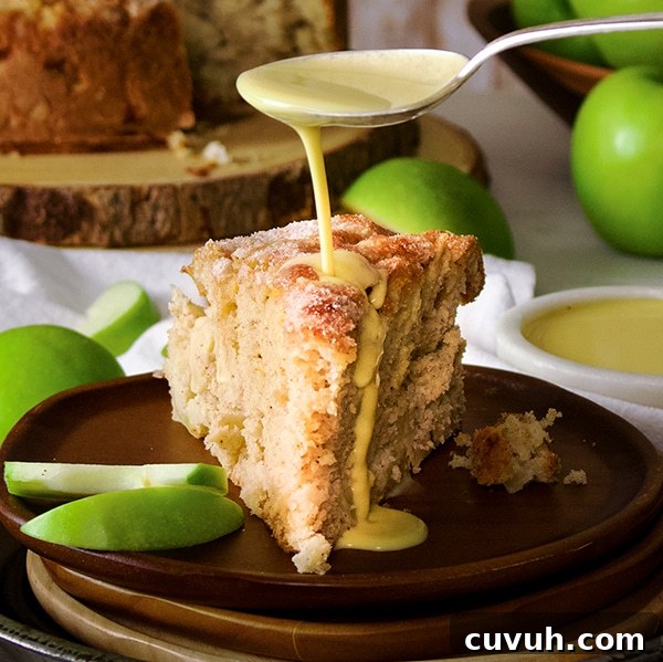 Drizzling a spoonful of custard sauce over a slice of Irish Apple Cake.
