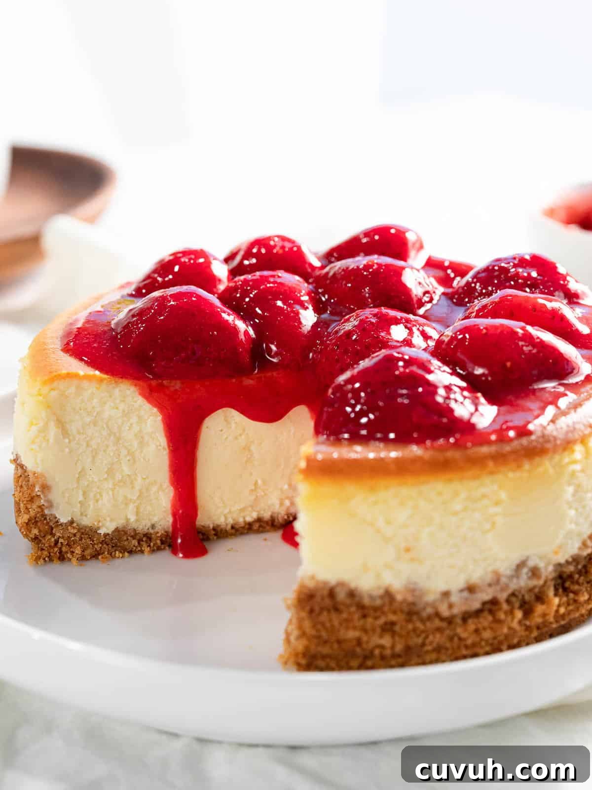 Decadent Strawberry Cheesecake Recipe with Fresh Berry Topping 2 Strawberry cheesecake with strawberry sauce and graham cracker crust.