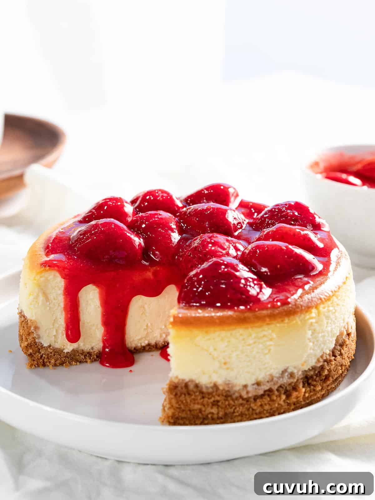 Decadent Strawberry Cheesecake Recipe with Fresh Berry Topping 14 Strawberry cheesecake with strawberry topping and graham cracker crust.