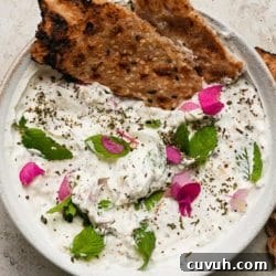 Creamy yogurt dip with herbs, edible flowers, and crispy sesame flatbread.