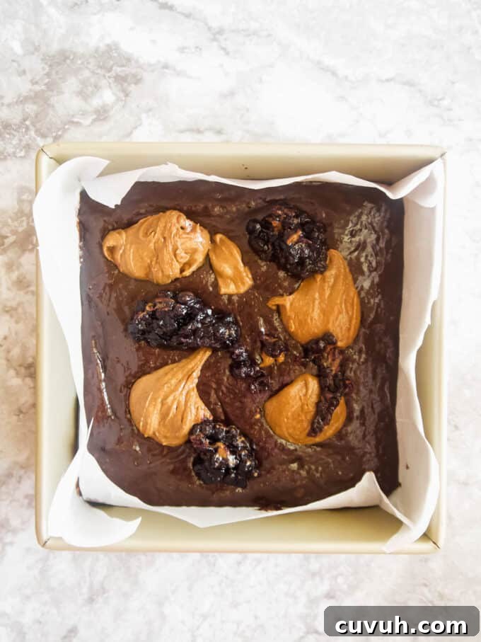 Paleo Almond Butter & Jelly Brownies — Gluten-Free Recipe 11 Almond butter and jelly dollops on top of brownie batter.