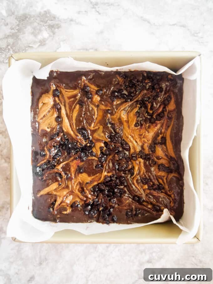 Paleo Almond Butter & Jelly Brownies — Gluten-Free Recipe 12 Swirls of almond butter and jelly on top of brownie before baking.