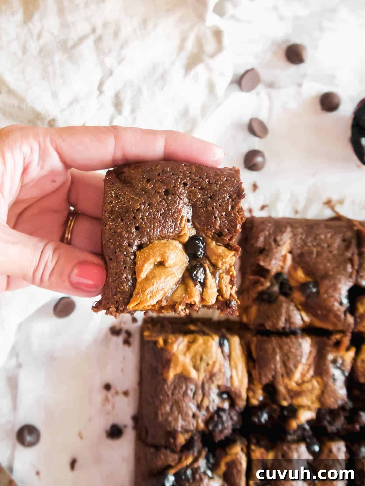 Paleo Almond Butter & Jelly Brownies — Gluten-Free Recipe 3 Lifting up a slice of the best Paleo brownies!