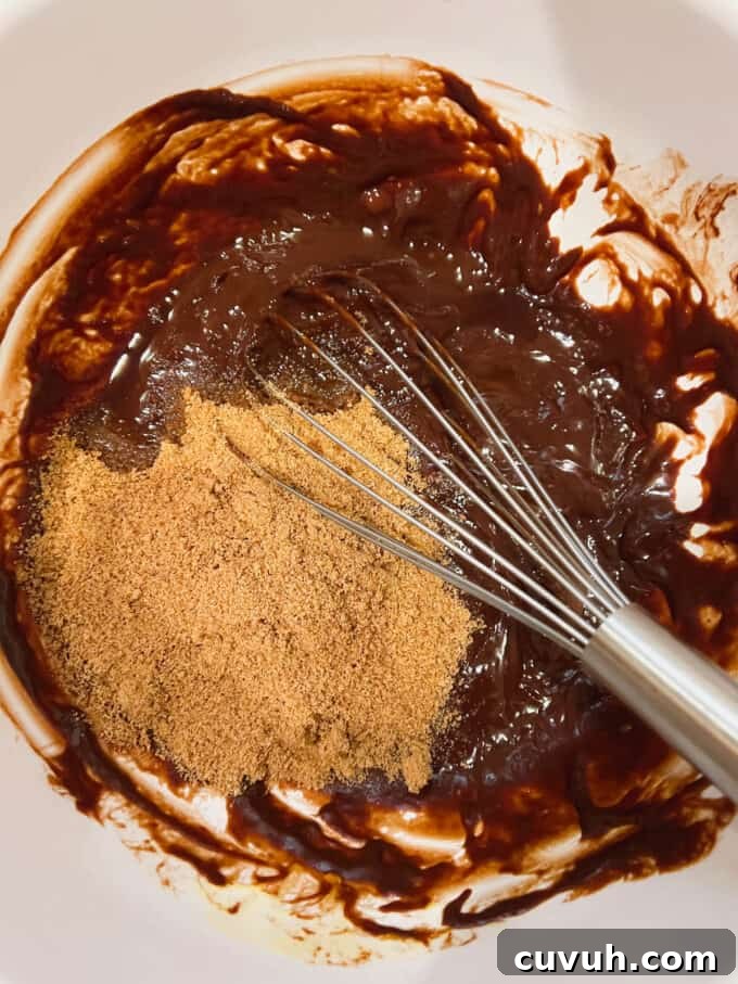 Paleo Almond Butter & Jelly Brownies — Gluten-Free Recipe 6 Adding vanilla and coconut sugar to the melted chocolate.