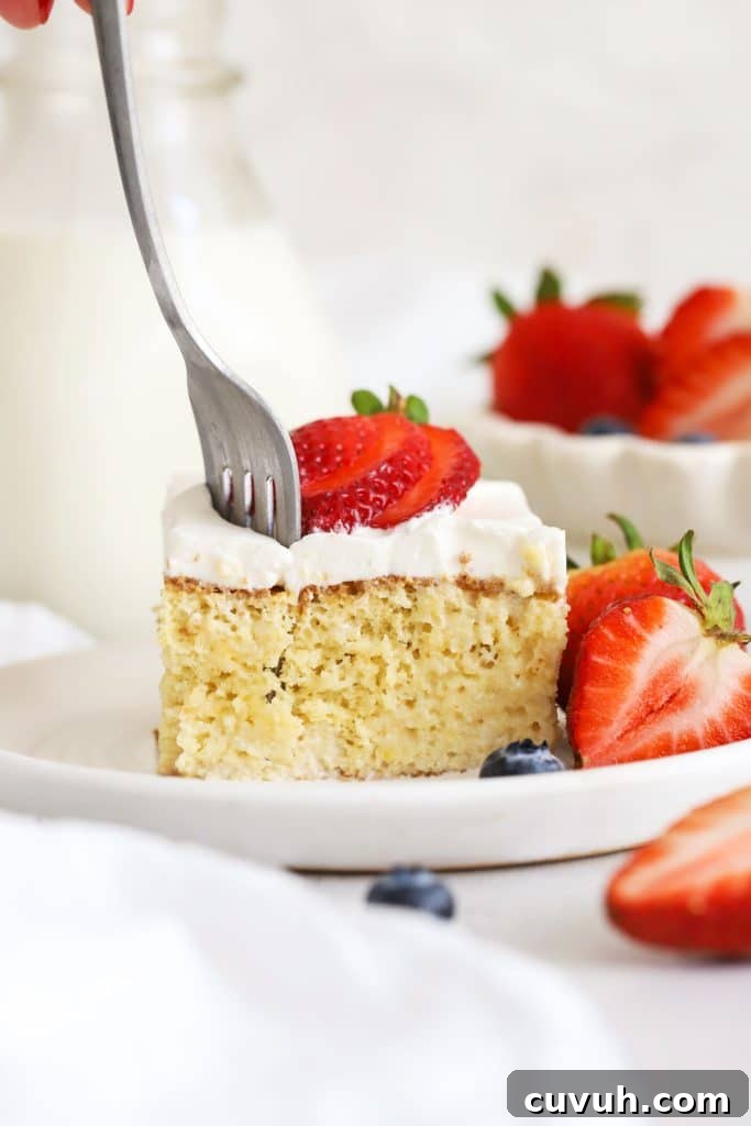 Moist Gluten-Free Yellow Sheet Cake Recipe for Parties 12 A fork getting a bite out of a slice of gluten-free tres leches cake