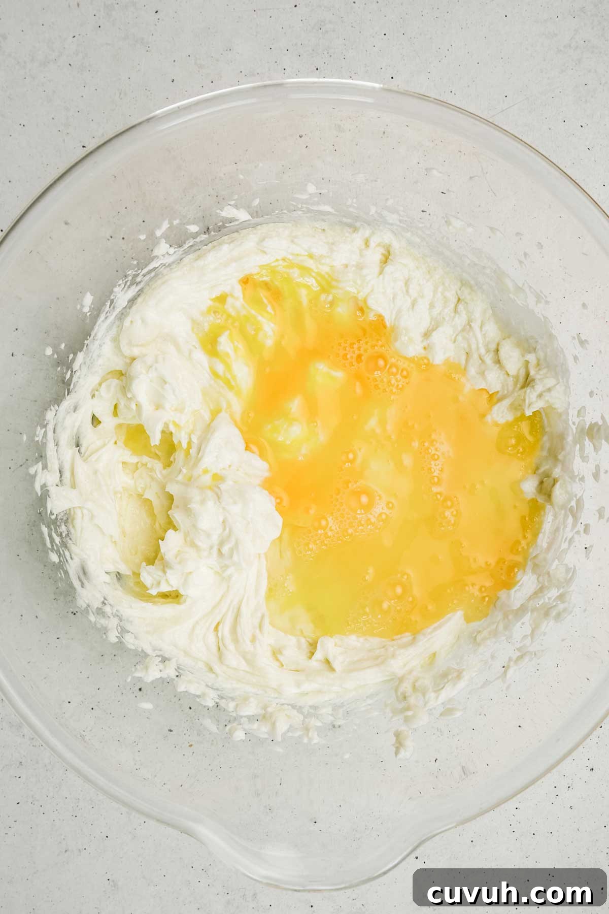 Classic New York Cheesecake Recipe: Creamy Oven-Baked Slice 4 Cream cheese and egg mixture in a mixing bowl