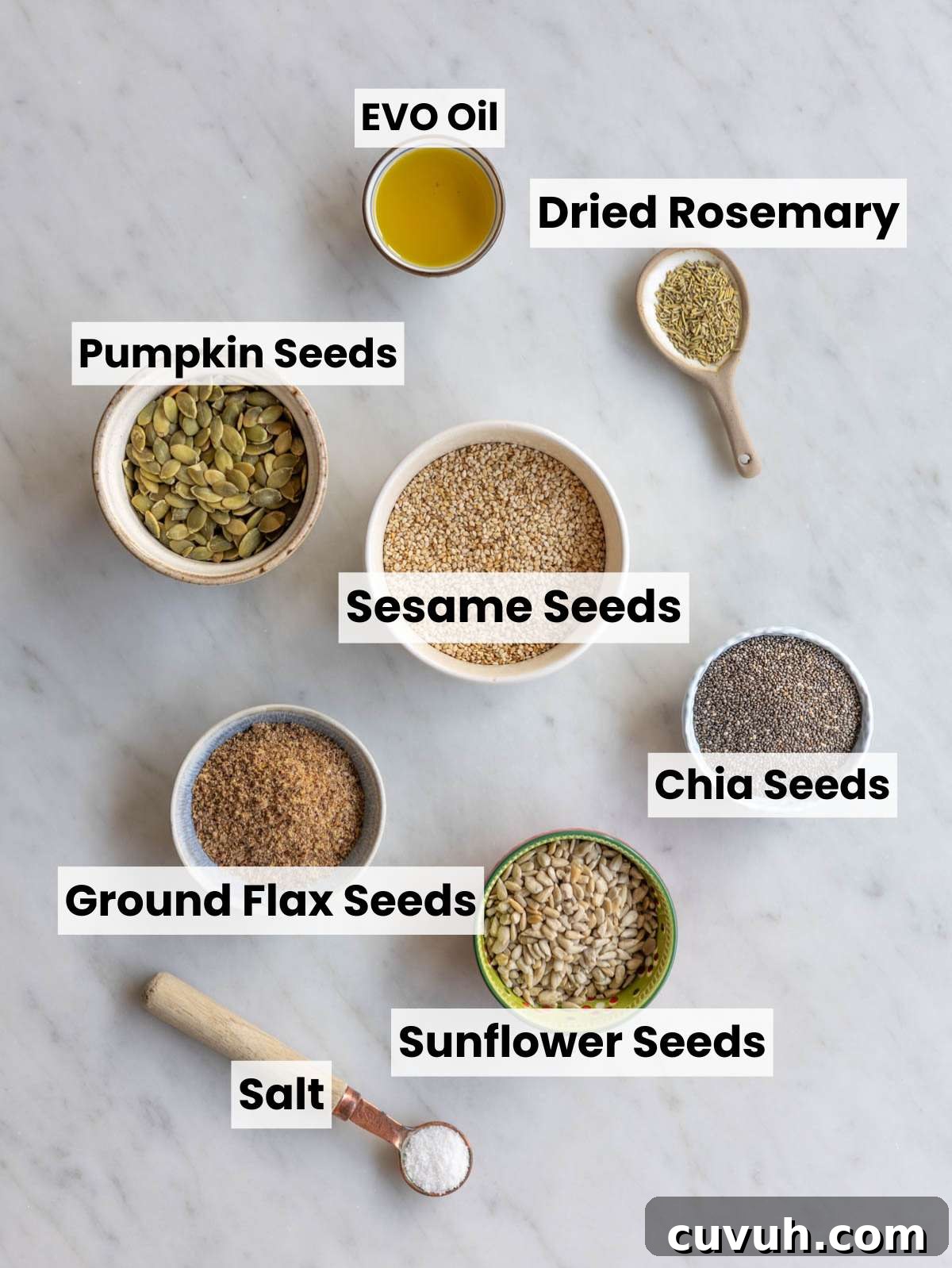 Crispy Seed Crackers: Flour-Free Savory Snack Recipe 3 Small bowls of sesame, pumpkin, sunflower, chia, and flax seeds on a marble surface.