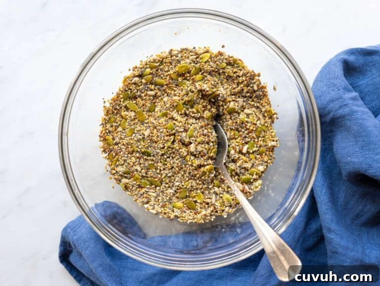 Crispy Seed Crackers: Flour-Free Savory Snack Recipe 10 Step 1 Mixing seeds, oil, and water in a bowl to make seed crackers mixture.