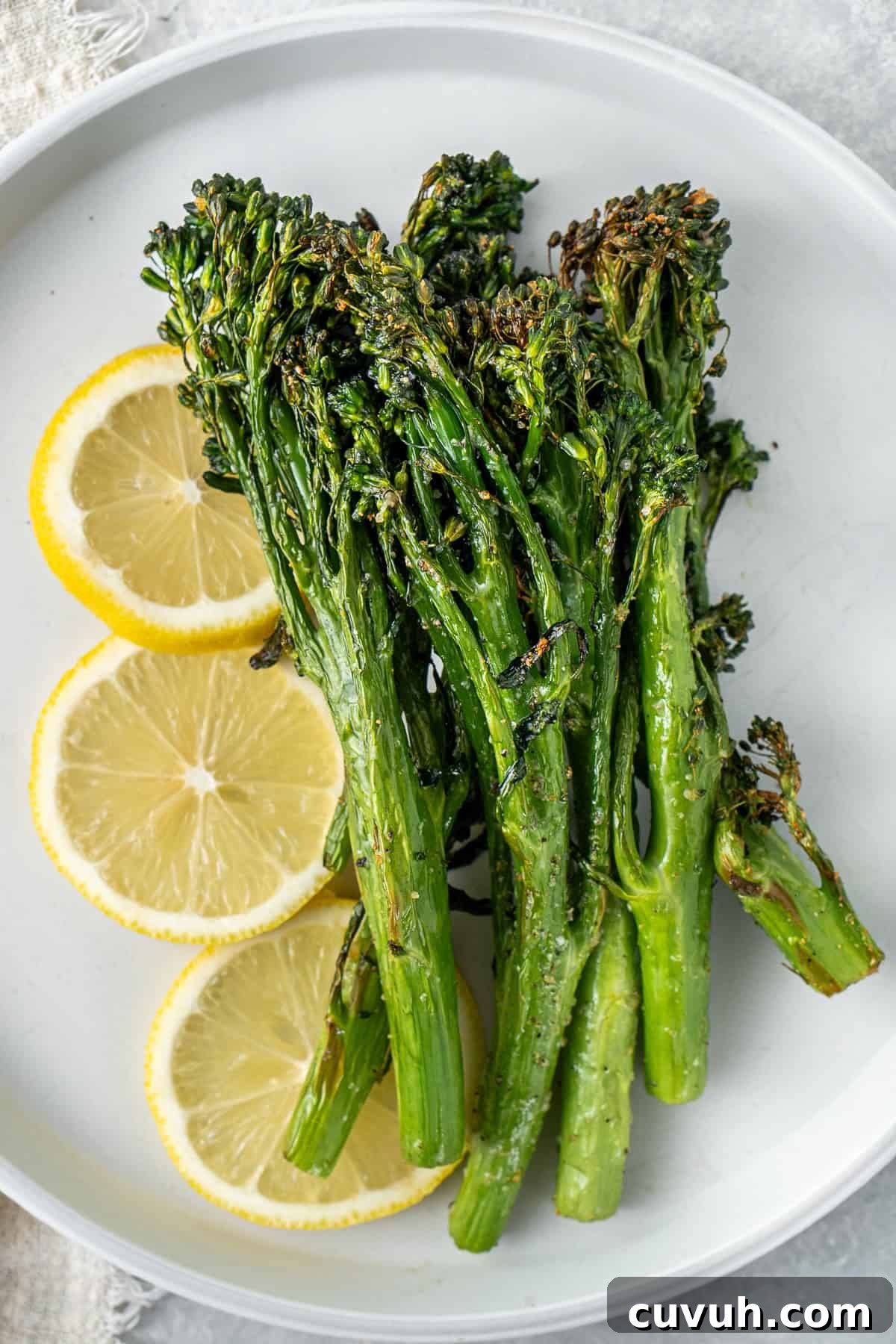 Crispy Air Fryer Broccolini with Lemon Garlic Salsa 10 Air fryer broccolini served on a plate with lemon.