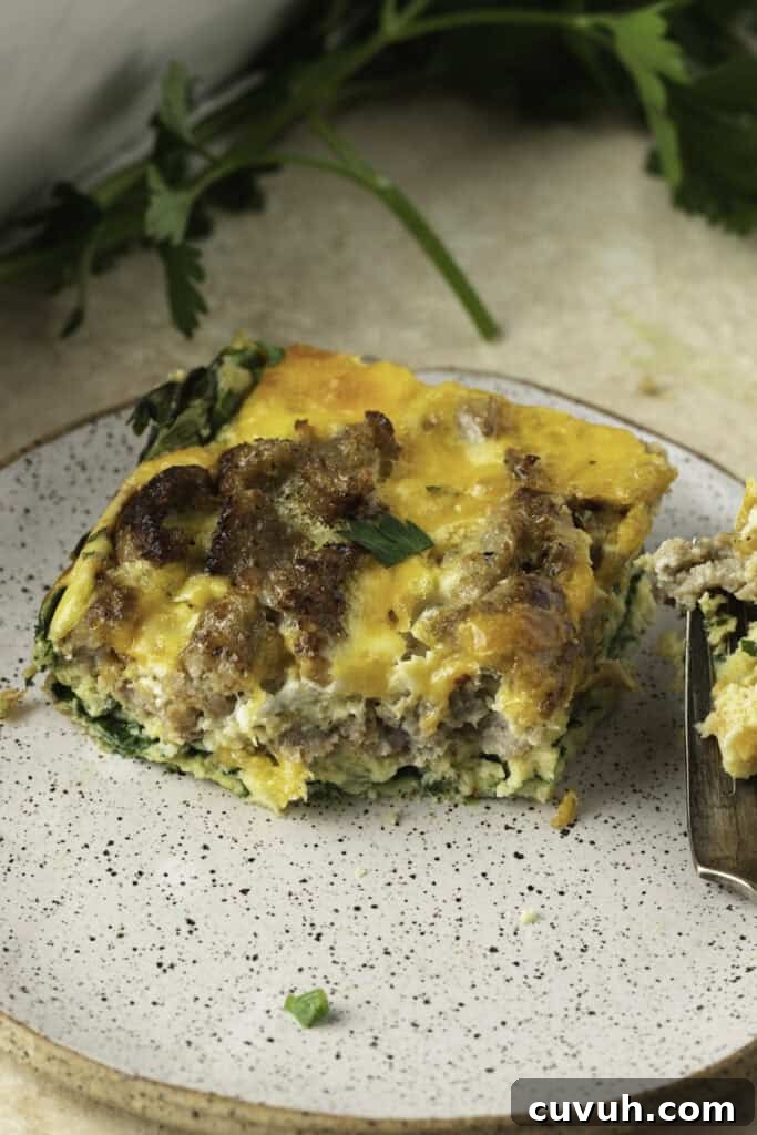 A square of keto breakfast casserole on a plate with a fork.