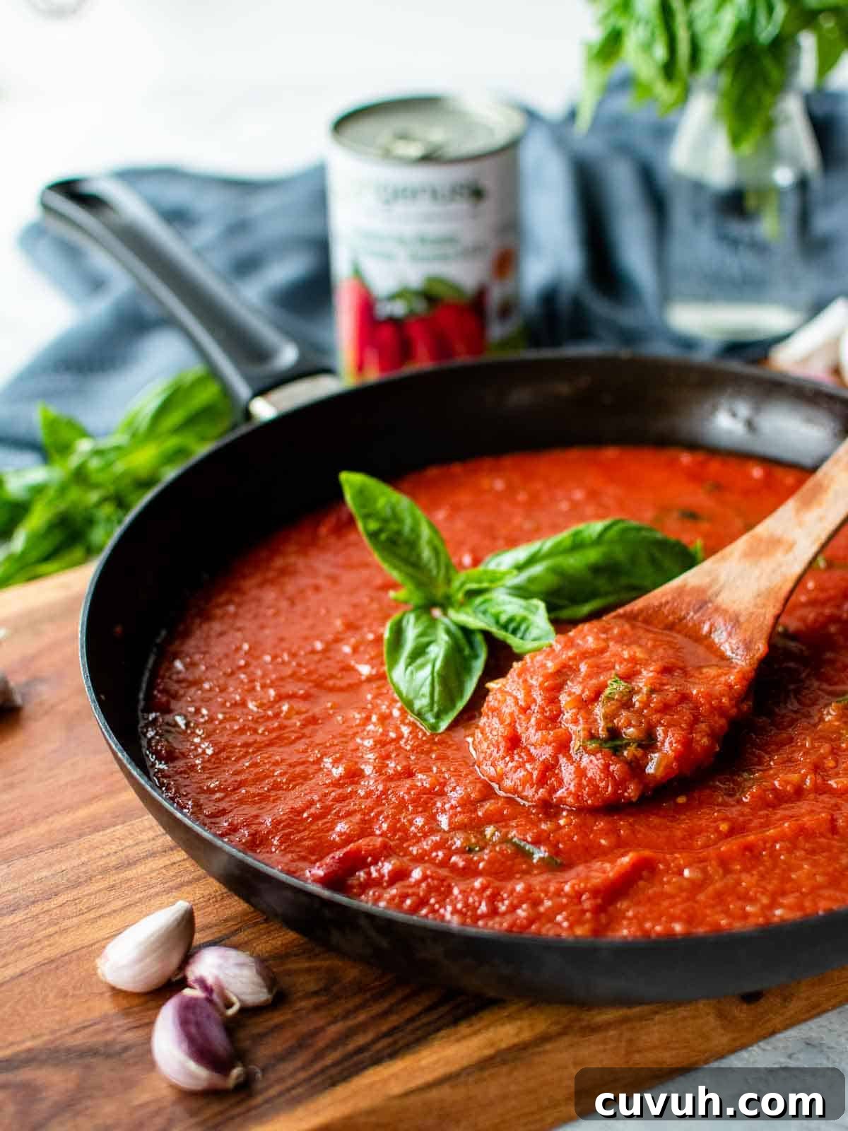 Authentic San Marzano Tomato Sauce Recipe for Homemade Pasta 2 San Marzano tomato sauce in a skillet with a sprig of basil in the centre.