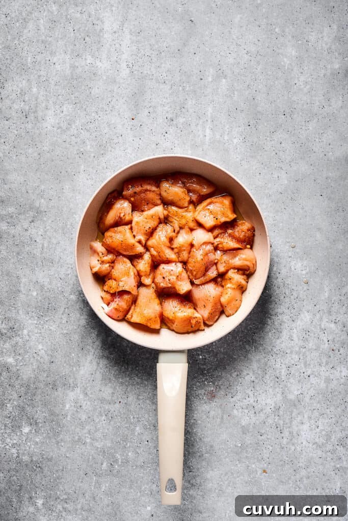 Raw chicken in a skillet.