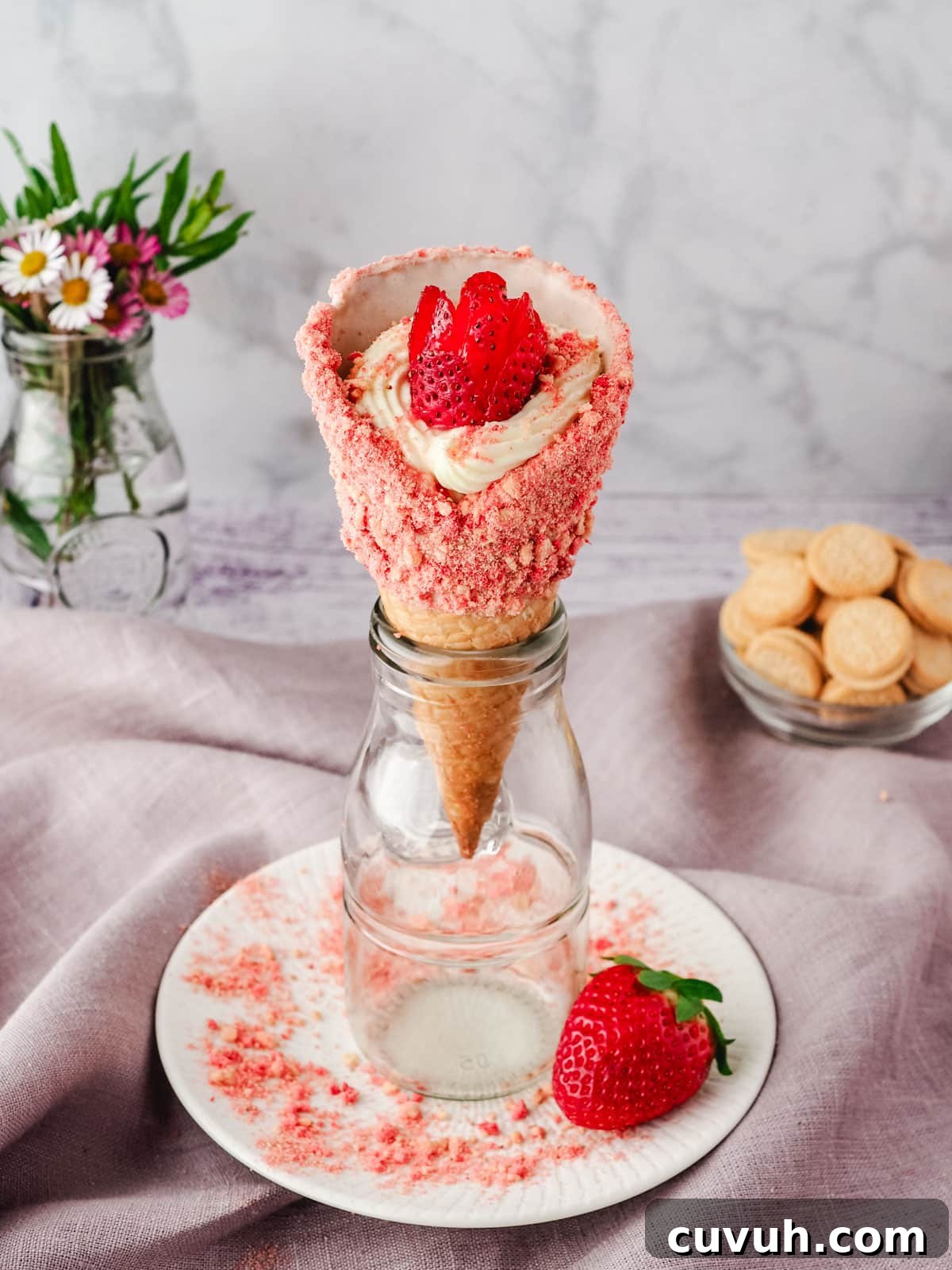 Strawberry Crunch Cheesecake Cones Recipe for Summer Treats 9 Serving strawberry crunch dessert cone rested upright in a glass jar.