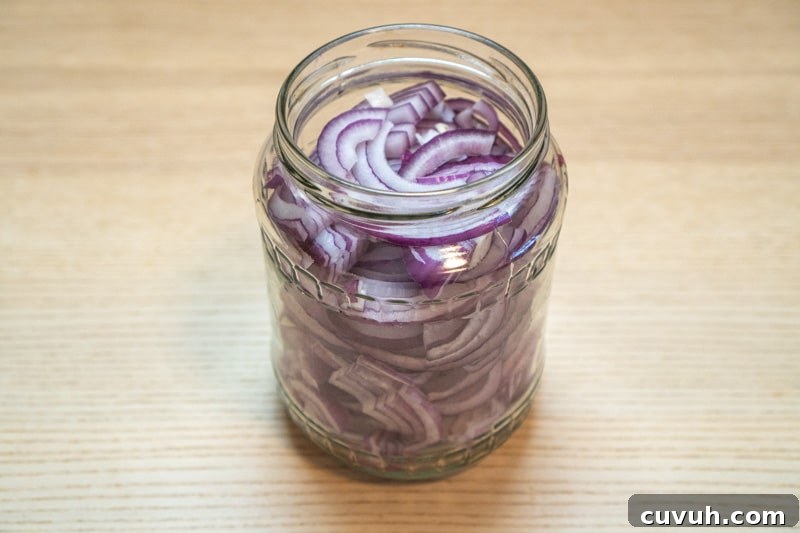 Sugar-Free Quick Pickled Red Onions Recipe for Tangy Flavor 5 Adding the sliced onions to a jar