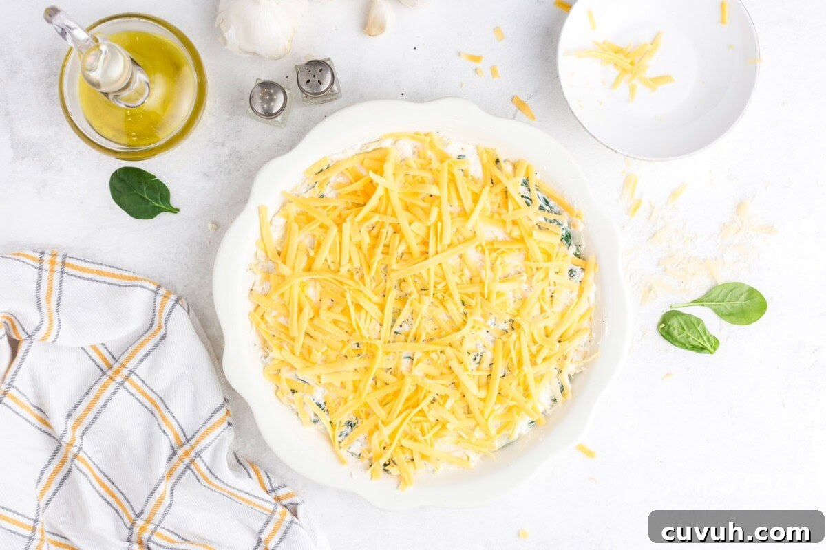 topping the spinach dip with cheese