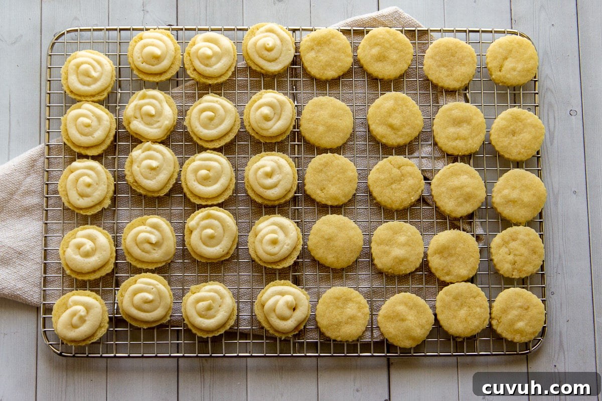 maple sandwich cookies being filled with buttercream on a cooling rack.