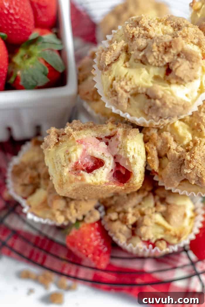 Strawberry Muffins Without Gluten — Quick Soft Recipe 6 Image shows a close up of gluten free strawberry muffins stacked on one another. the top muffin has a bit taken out of it to show the texture and strawberries inside.