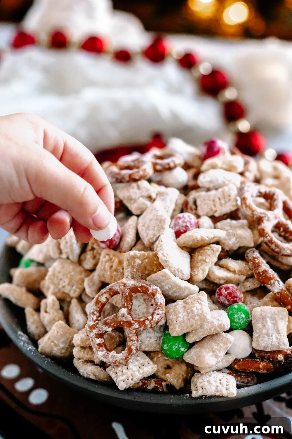Christmas Puppy Chow Recipe — Festive Reindeer Munch Treats 6 Small hand reaching in to snag a bit of the snack mix during my photo shoot.