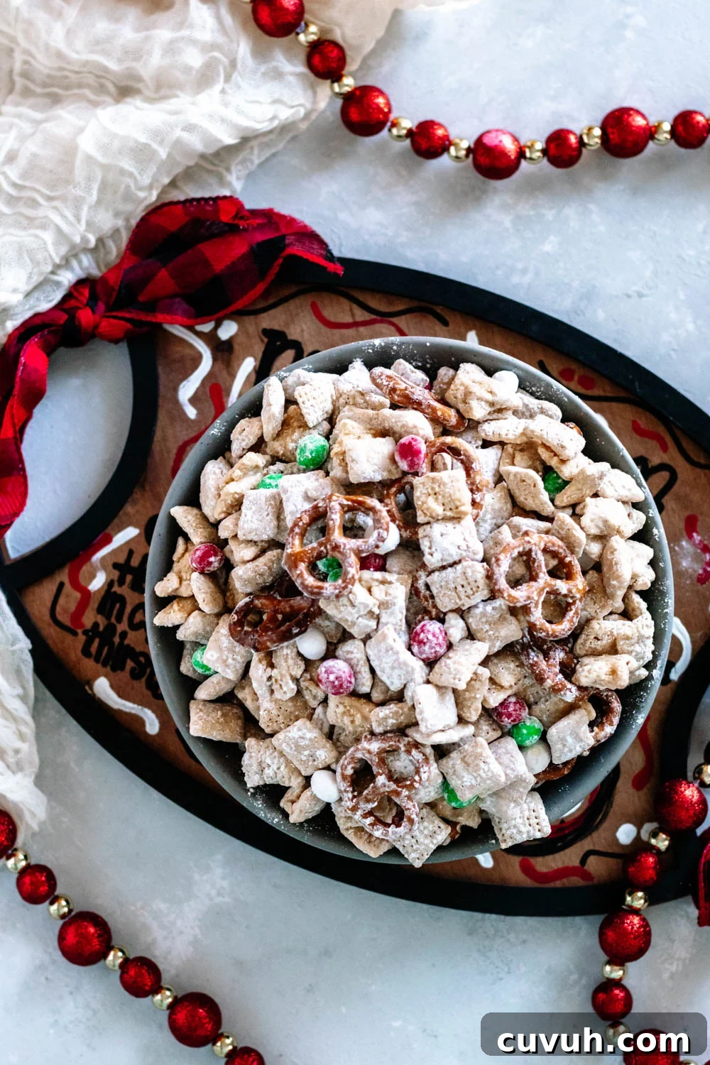 Christmas Puppy Chow Recipe — Festive Reindeer Munch Treats 4 Overhead view of the Christmas Muddy Buddy Mix in a grey bowl on a "Cookies for Santa" tray. This is one serving suggestion