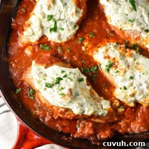 A cast iron pan with ricotta chicken and marinara sauce.
