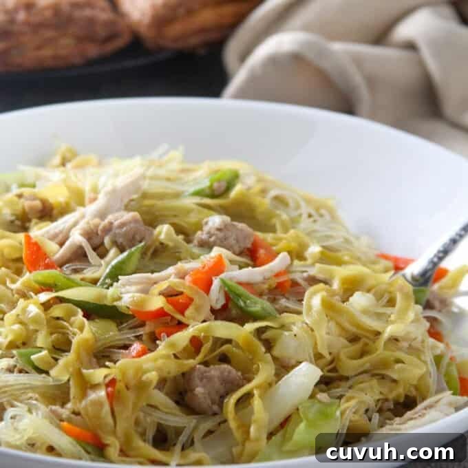eating pancit langlang from a white bowl