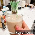 Marie holding up the finished Date and Banana Protein Smoothie with a straw