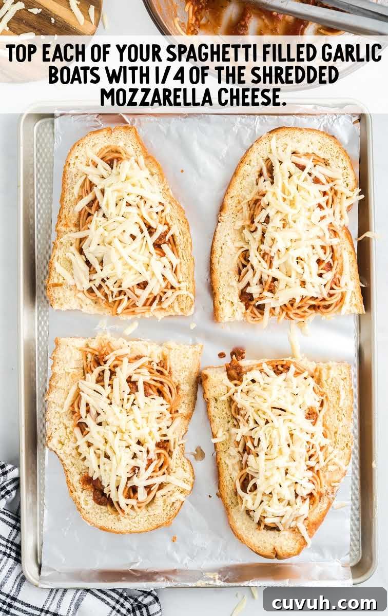 spaghetti stuffed garlic bread process shot of shredded mozzarella cheese being topped on top of spaghetti bread