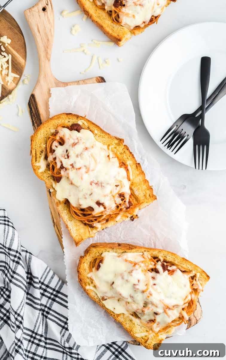 close up overhead shot of a piece of spaghetti stuffed garlic bread on a wooden board