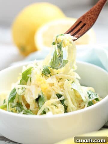 Person using a fork to take a bite of spaghetti squash.