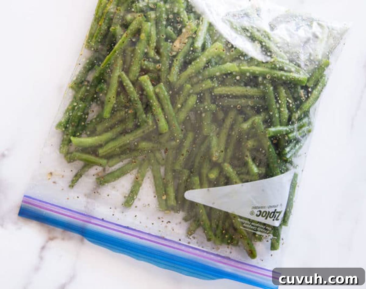 Ziplock bag filled with fresh green beans marinating in olive oil, lemon and garlic.
