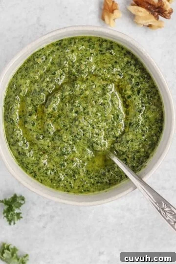 Pesto in a small bowl with a spoon in the pesto.