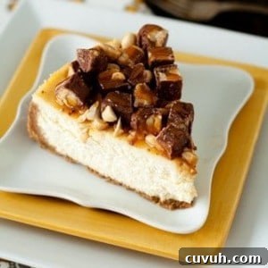 Slice of Snickers cheesecake on a stack of yellow and white plates