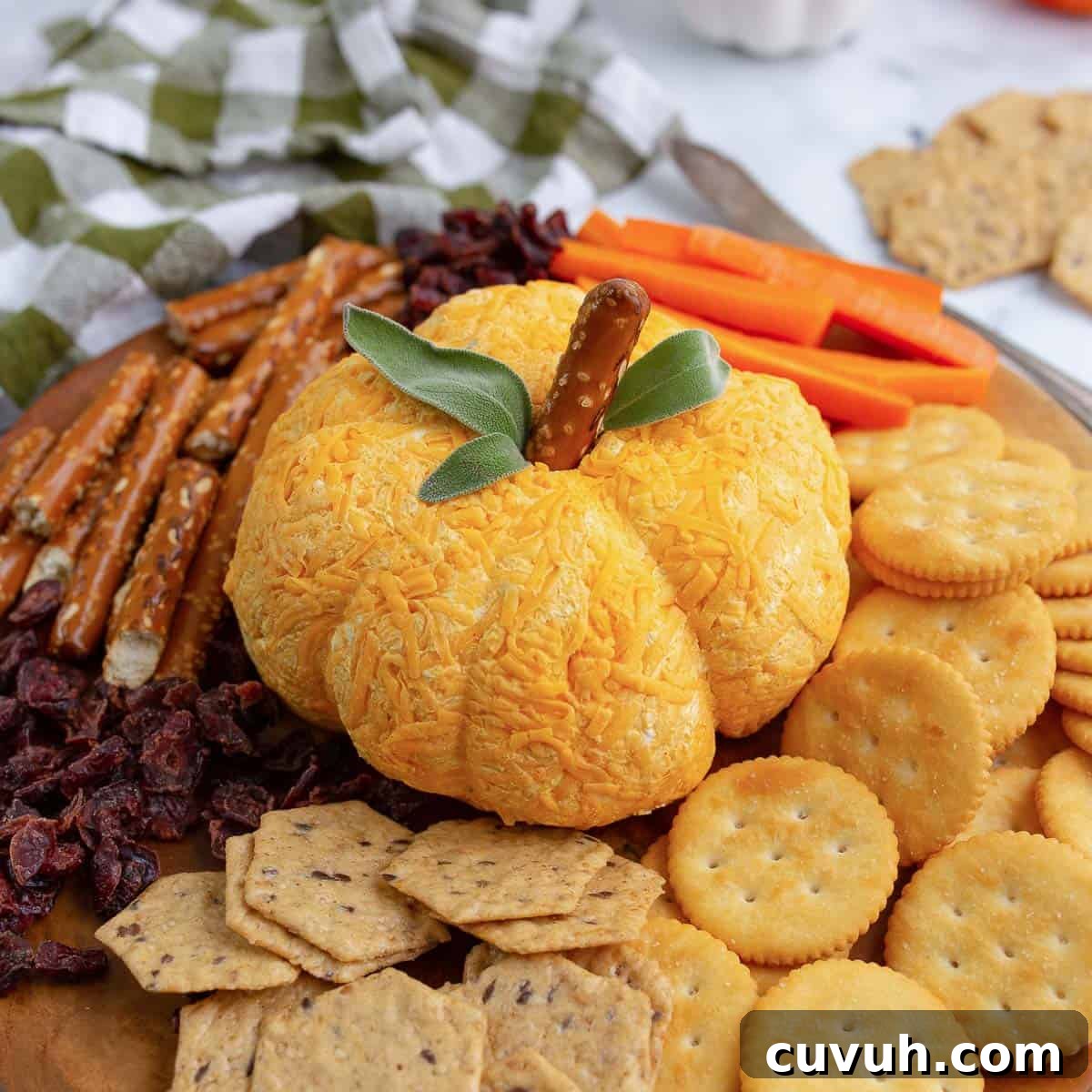 Thanksgiving Appetizers You Can Make Ahead for Stress-Free Hosting 7 Pumpkin cheese ball apptizer dip shaped into a pumpkin.