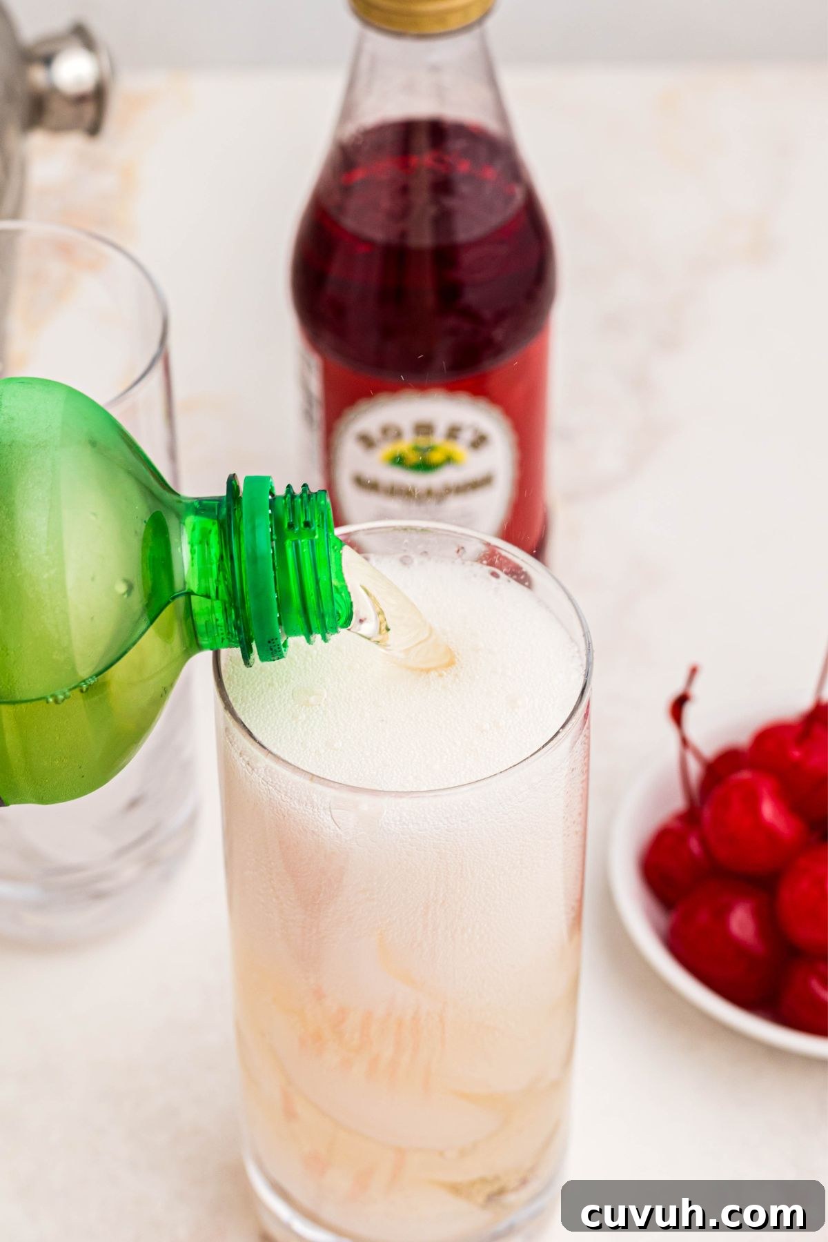 Ginger ale being poured into a clear tall glass.