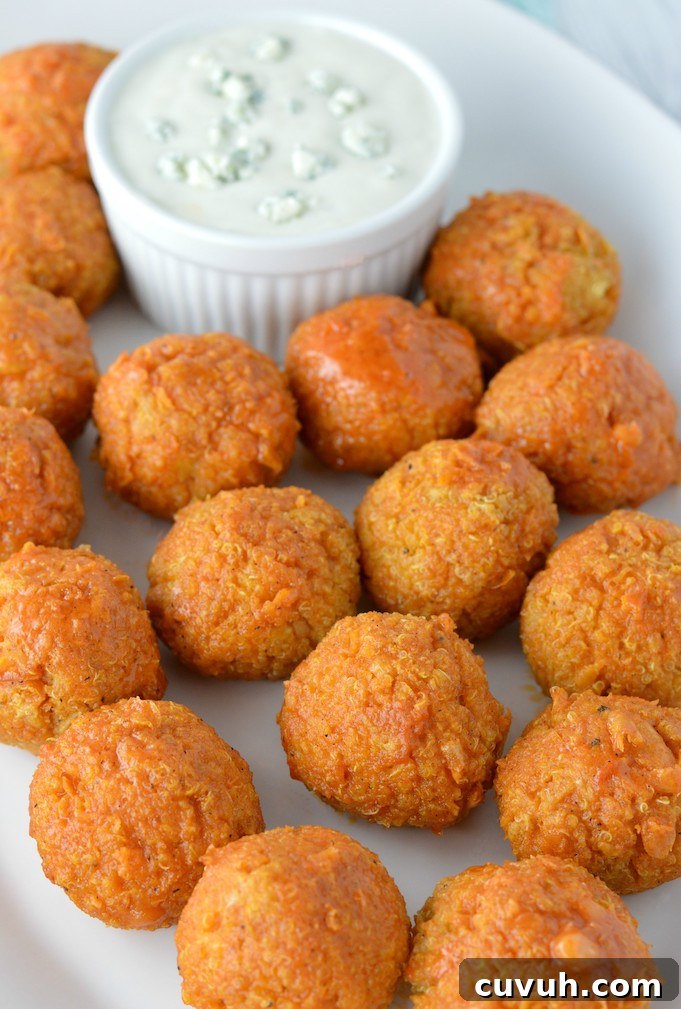 buffalo quinoa bites in white plate with blue cheese dressing in bowl