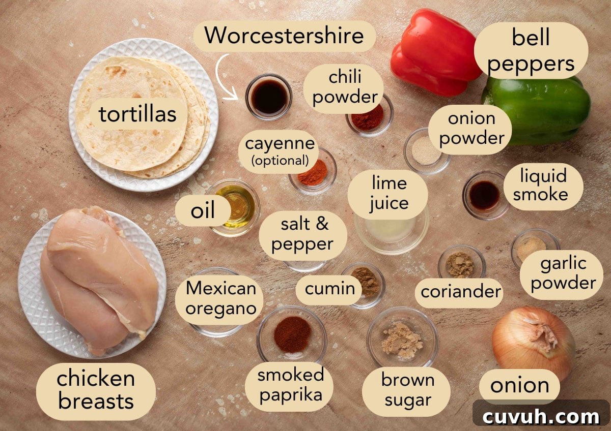 Crispy Air Fryer Chicken Fajitas with Peppers and Onions 3 Labeled flat lay of ingredients for air fryer chicken fajitas, including raw chicken breasts, tortillas, bell peppers, onion, spices, oil, lime juice, and Worcestershire sauce arranged on a textured surface.