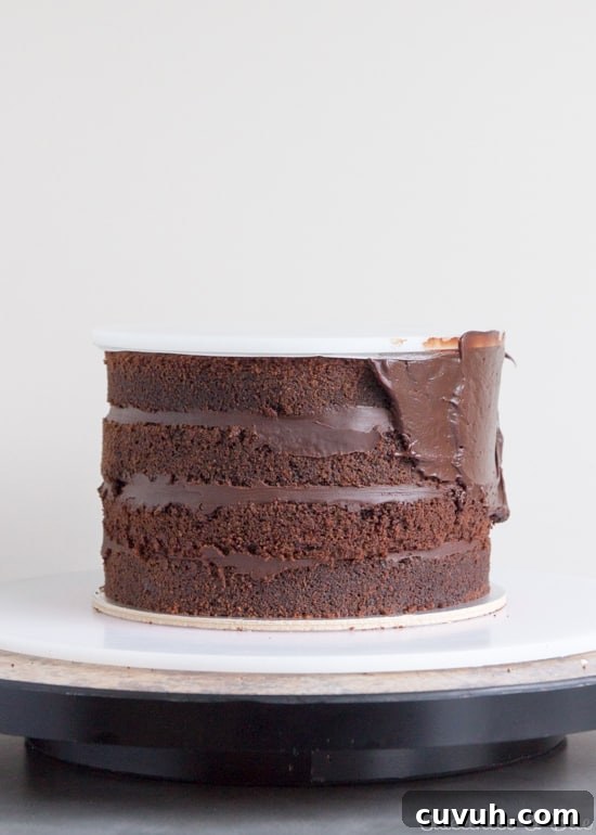 Ganache being spread around the sides of the cake.
