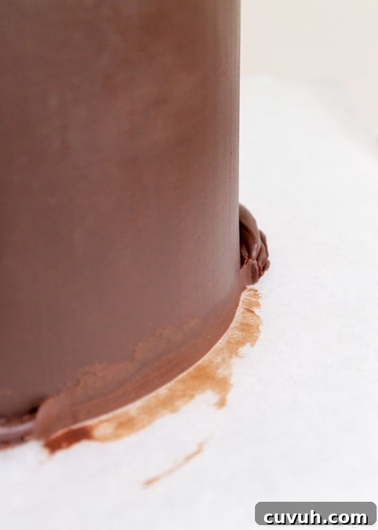 Starting to scrape away the excess ganache.