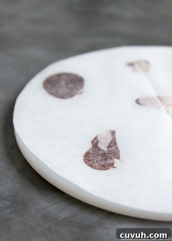 White acrylic ganache 'lid' covered in baking paper.