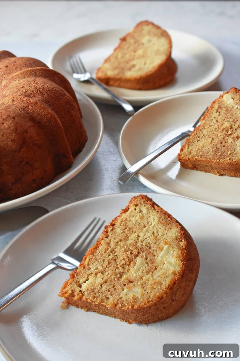 A shot of three slices of apple Bundt Cake on white plates with forks, next to the cake.