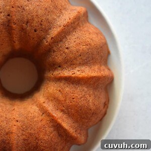 An overhead shot of 3/4 of an apple Bundt Cake on a white plate