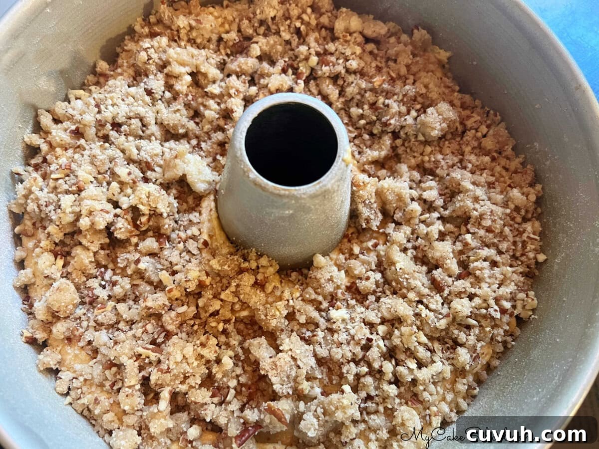 Moist Pumpkin Pound Cake Recipe for Fall Baking 5 Streusel topping on top of cake batter, in bundt pan.