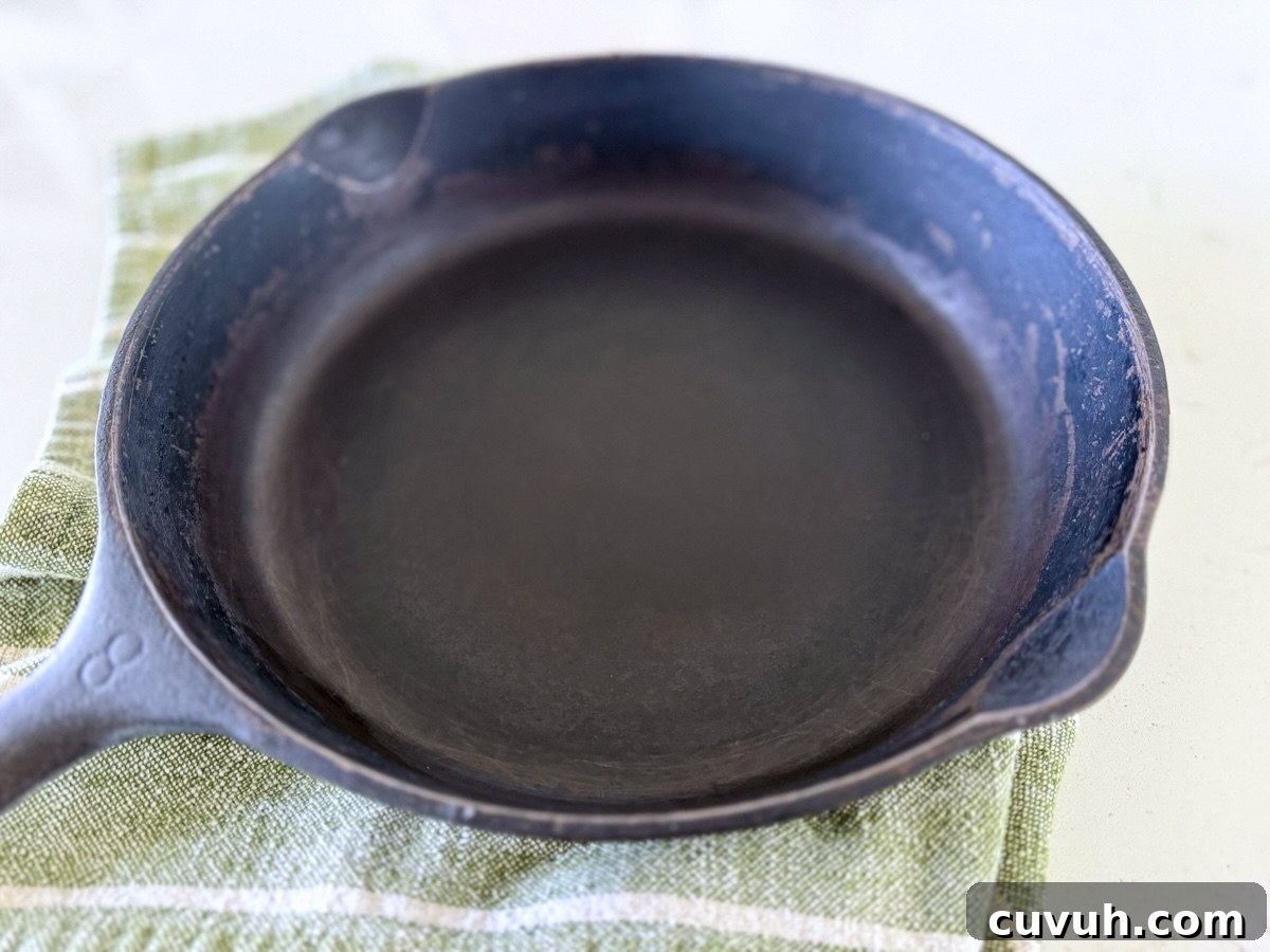 How to Clean and Care for a Cast Iron Skillet: Tips for Lasting Seasoning 4 clean cast iron skillet on green towel